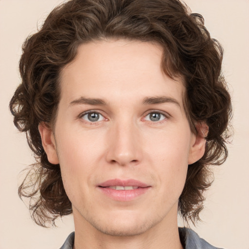 Joyful white young-adult male with medium  brown hair and grey eyes