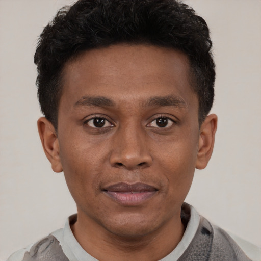 Joyful latino young-adult male with short  brown hair and brown eyes