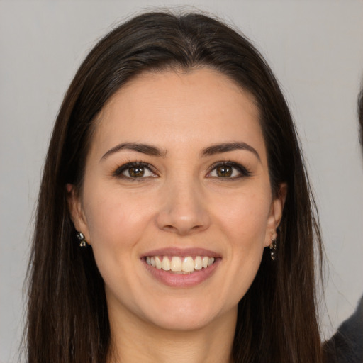 Joyful white young-adult female with long  brown hair and brown eyes