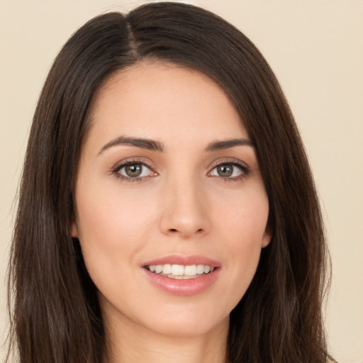 Joyful white young-adult female with long  brown hair and brown eyes