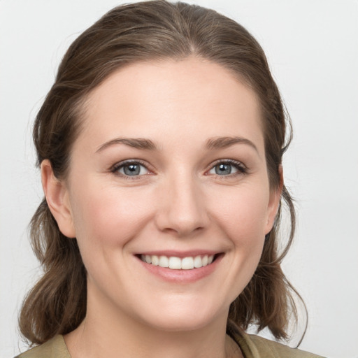 Joyful white young-adult female with medium  brown hair and grey eyes