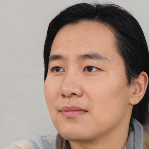 Joyful asian young-adult male with medium  brown hair and brown eyes