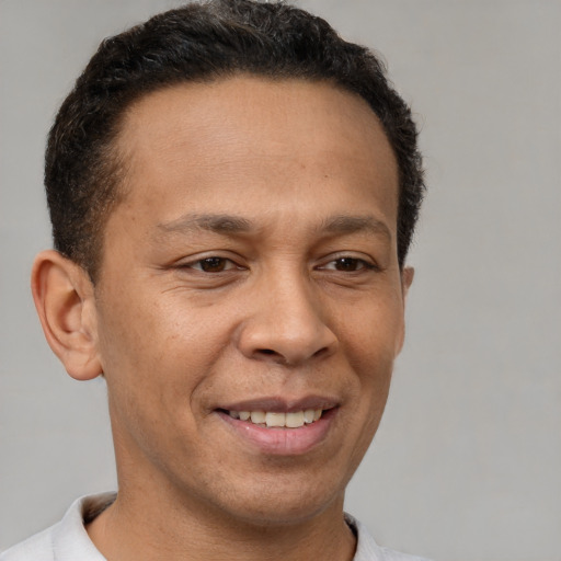 Joyful latino adult male with short  brown hair and brown eyes