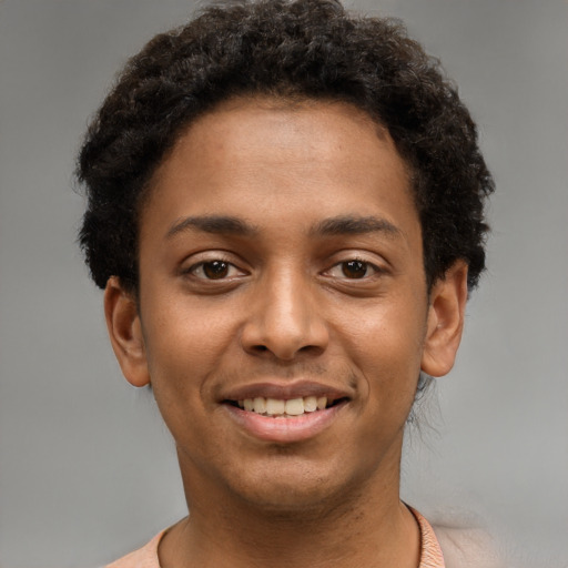 Joyful black young-adult male with short  brown hair and brown eyes