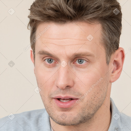 Joyful white adult male with short  brown hair and grey eyes