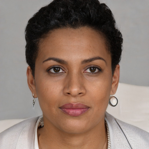 Joyful black young-adult female with short  black hair and brown eyes