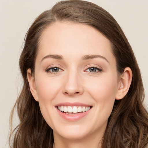 Joyful white young-adult female with long  brown hair and blue eyes