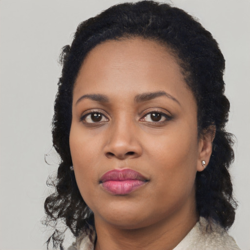 Joyful black young-adult female with long  black hair and brown eyes