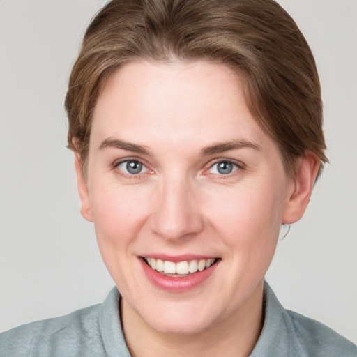 Joyful white young-adult female with short  brown hair and blue eyes