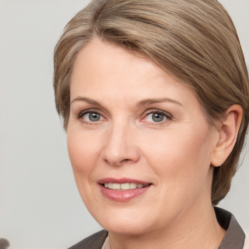 Joyful white adult female with medium  brown hair and grey eyes