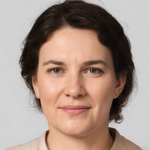 Joyful white adult female with medium  brown hair and grey eyes