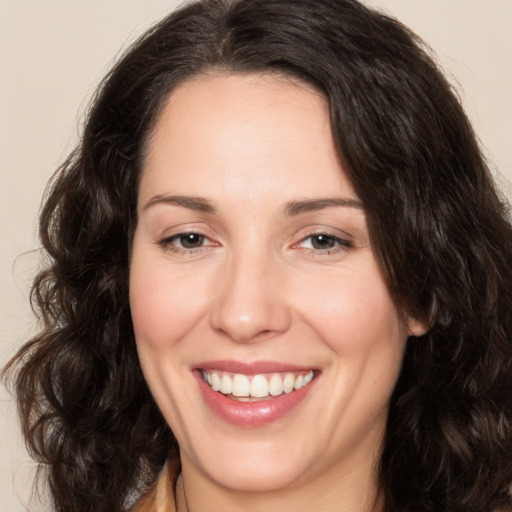 Joyful white adult female with long  brown hair and brown eyes