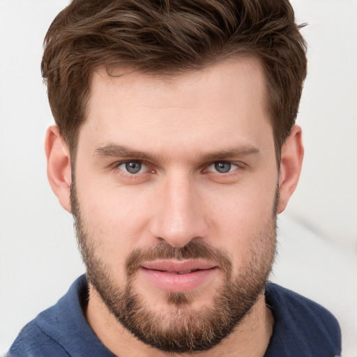 Joyful white young-adult male with short  brown hair and grey eyes