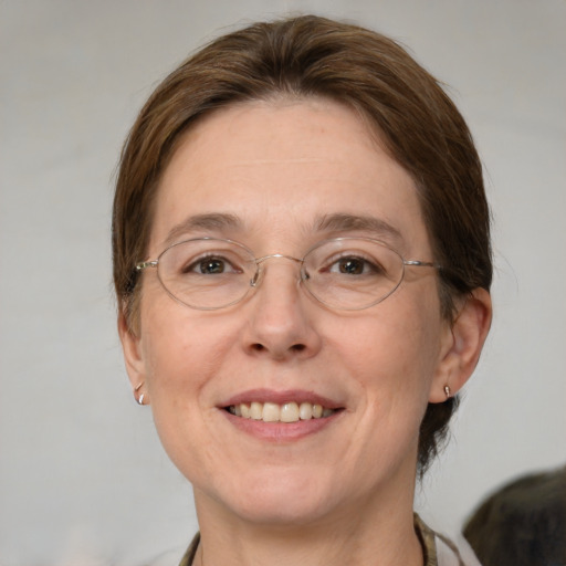 Joyful white adult female with medium  brown hair and green eyes