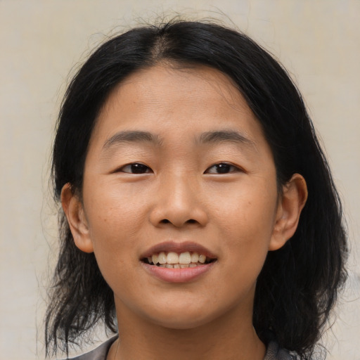 Joyful asian young-adult female with medium  black hair and brown eyes