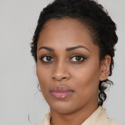 Joyful black young-adult female with long  brown hair and brown eyes