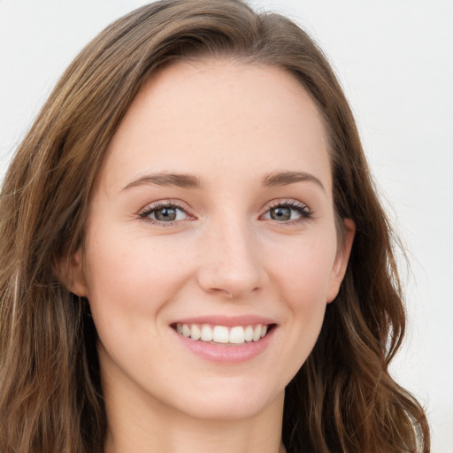 Joyful white young-adult female with long  brown hair and green eyes