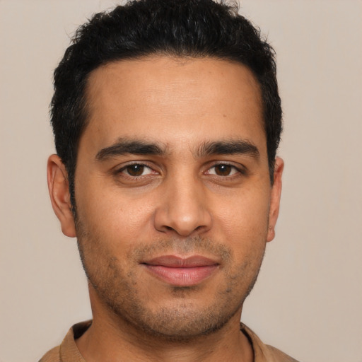 Joyful latino young-adult male with short  black hair and brown eyes