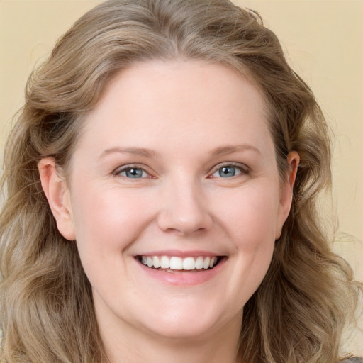 Joyful white young-adult female with long  brown hair and blue eyes