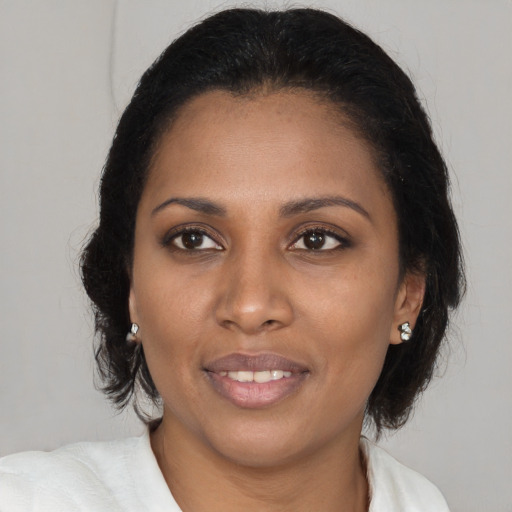 Joyful black young-adult female with medium  brown hair and brown eyes