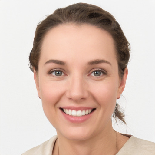 Joyful white young-adult female with medium  brown hair and grey eyes