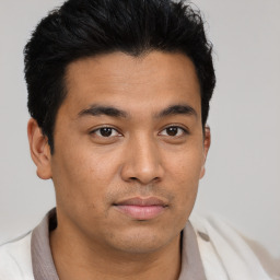 Joyful latino young-adult male with short  brown hair and brown eyes