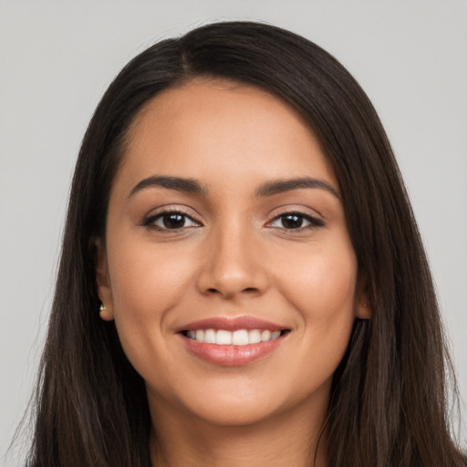 Joyful latino young-adult female with long  brown hair and brown eyes