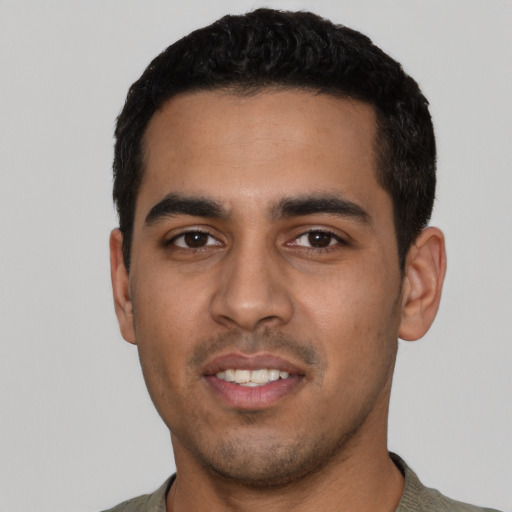 Joyful latino young-adult male with short  black hair and brown eyes