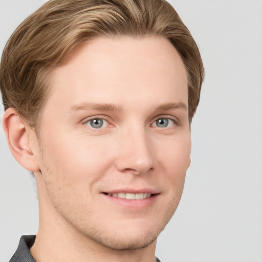 Joyful white young-adult male with short  brown hair and grey eyes