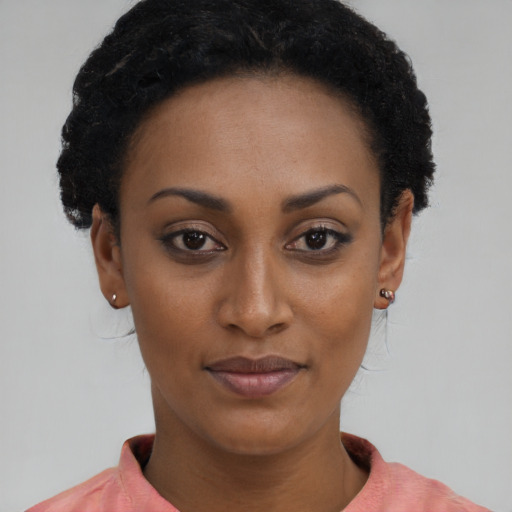 Joyful black young-adult female with short  brown hair and brown eyes