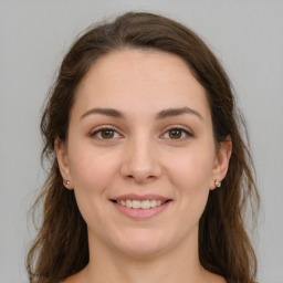 Joyful white young-adult female with long  brown hair and green eyes