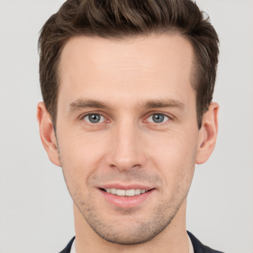 Joyful white young-adult male with short  brown hair and grey eyes