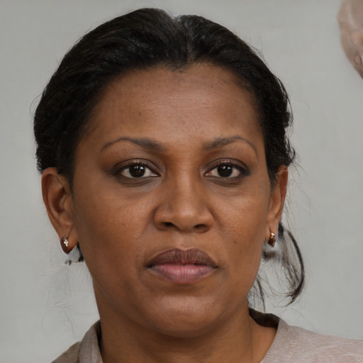 Joyful black adult female with medium  brown hair and brown eyes