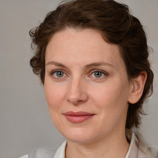 Joyful white adult female with medium  brown hair and blue eyes