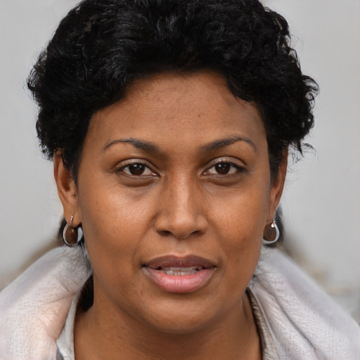 Joyful latino adult female with short  brown hair and brown eyes
