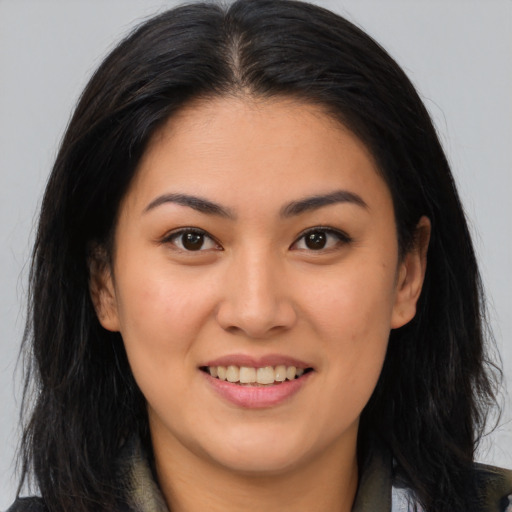 Joyful latino young-adult female with long  brown hair and brown eyes
