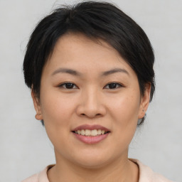 Joyful asian young-adult female with short  brown hair and brown eyes