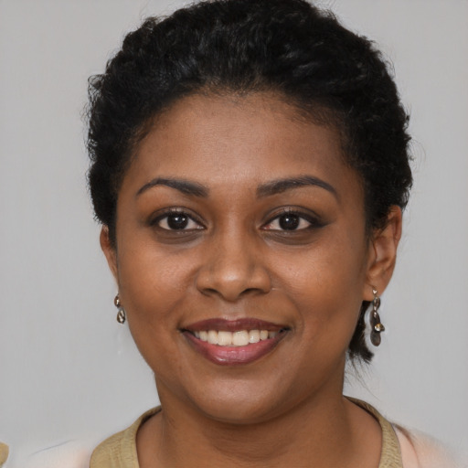 Joyful black young-adult female with short  brown hair and brown eyes
