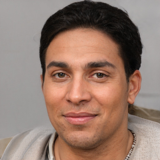 Joyful white adult male with short  black hair and brown eyes