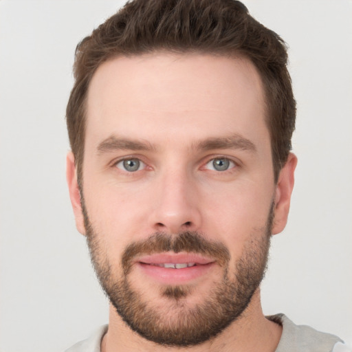 Joyful white young-adult male with short  brown hair and grey eyes