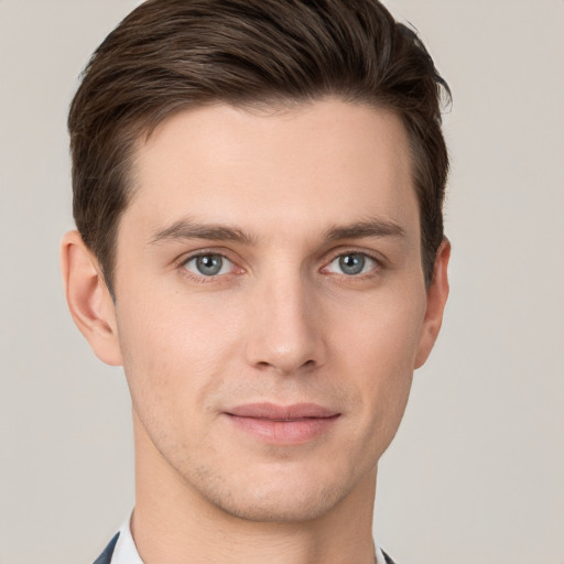 Joyful white young-adult male with short  brown hair and grey eyes