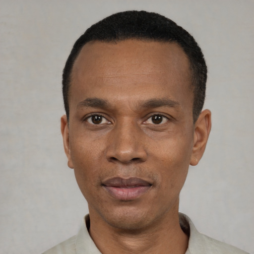Joyful black adult male with short  black hair and brown eyes