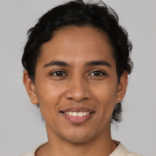 Joyful latino young-adult male with short  brown hair and brown eyes