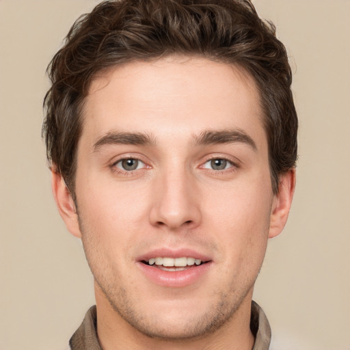 Joyful white young-adult male with short  brown hair and grey eyes