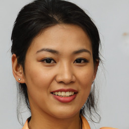 Joyful asian young-adult female with medium  brown hair and brown eyes