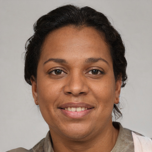 Joyful black adult female with medium  brown hair and brown eyes