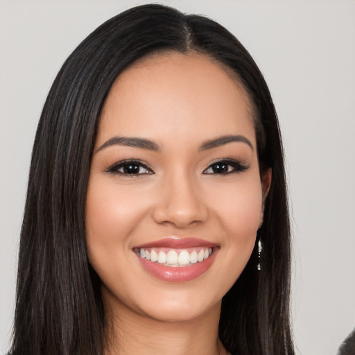 Joyful latino young-adult female with long  black hair and brown eyes