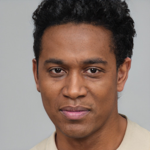 Joyful black young-adult male with short  black hair and brown eyes