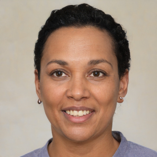 Joyful latino adult female with short  black hair and brown eyes