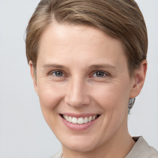 Joyful white young-adult female with short  brown hair and grey eyes